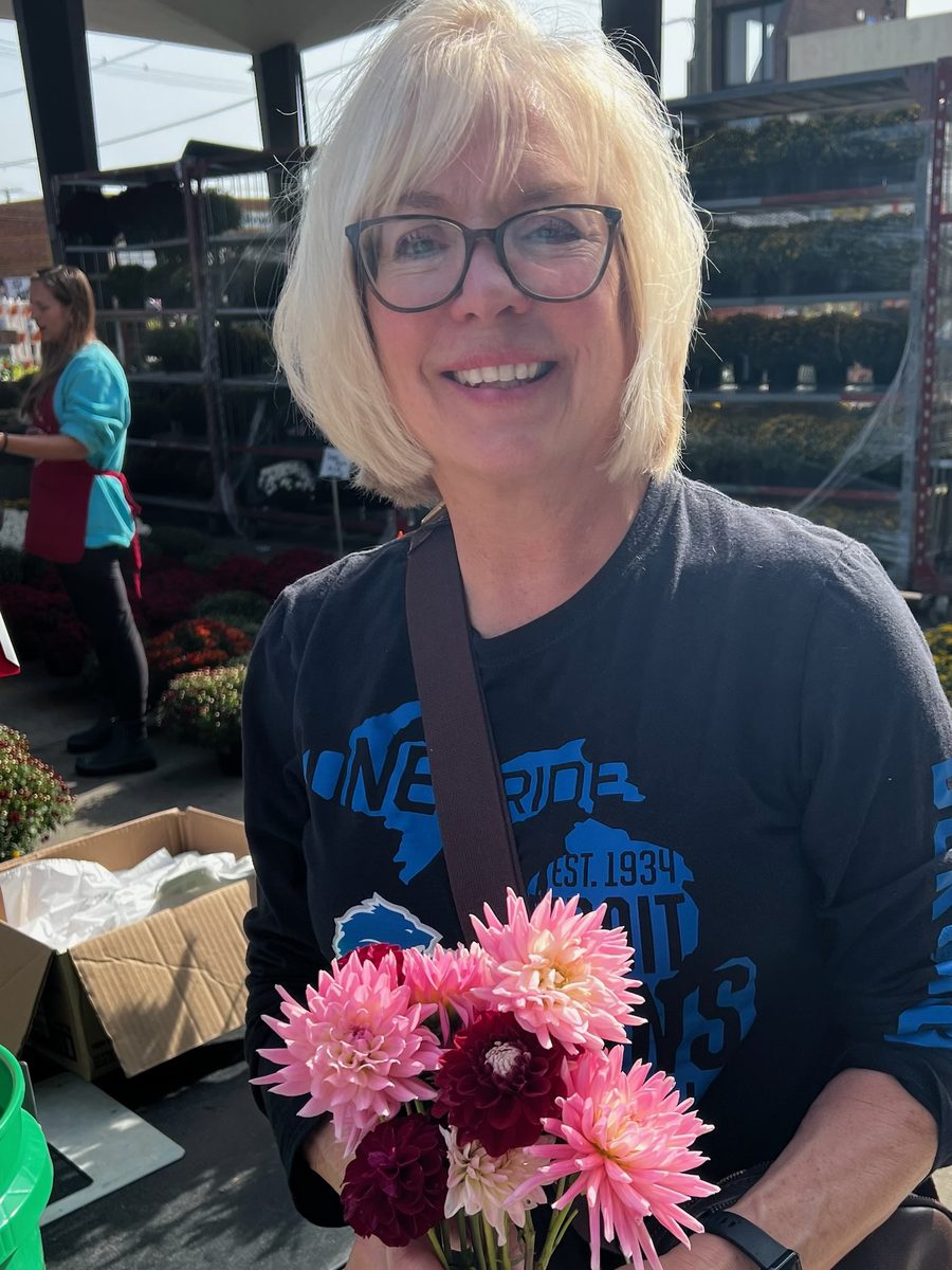 Kim at the flower market holding pink dahlias