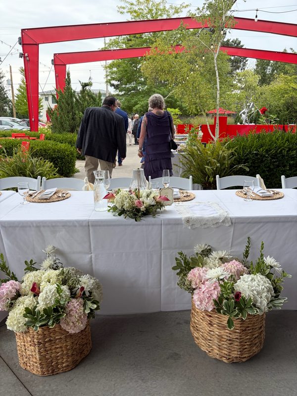 Basket arrangements of hydrangea and roses at an outdoor reception