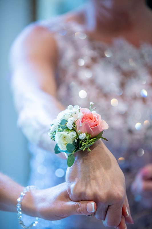 Wrist corsage with a pink rose and white blooms