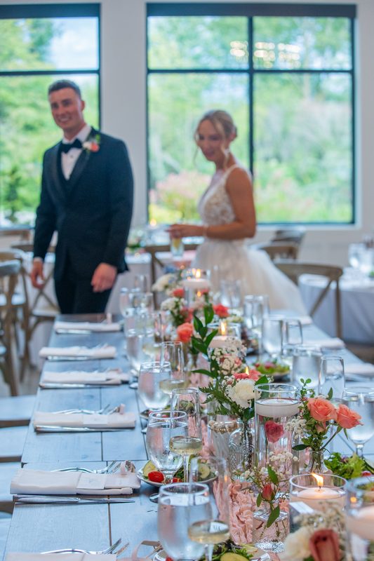 Bride and groom at the head table with floral arrangements