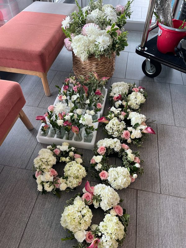 Hydrangea and calla lily arrangements lined up before delivery