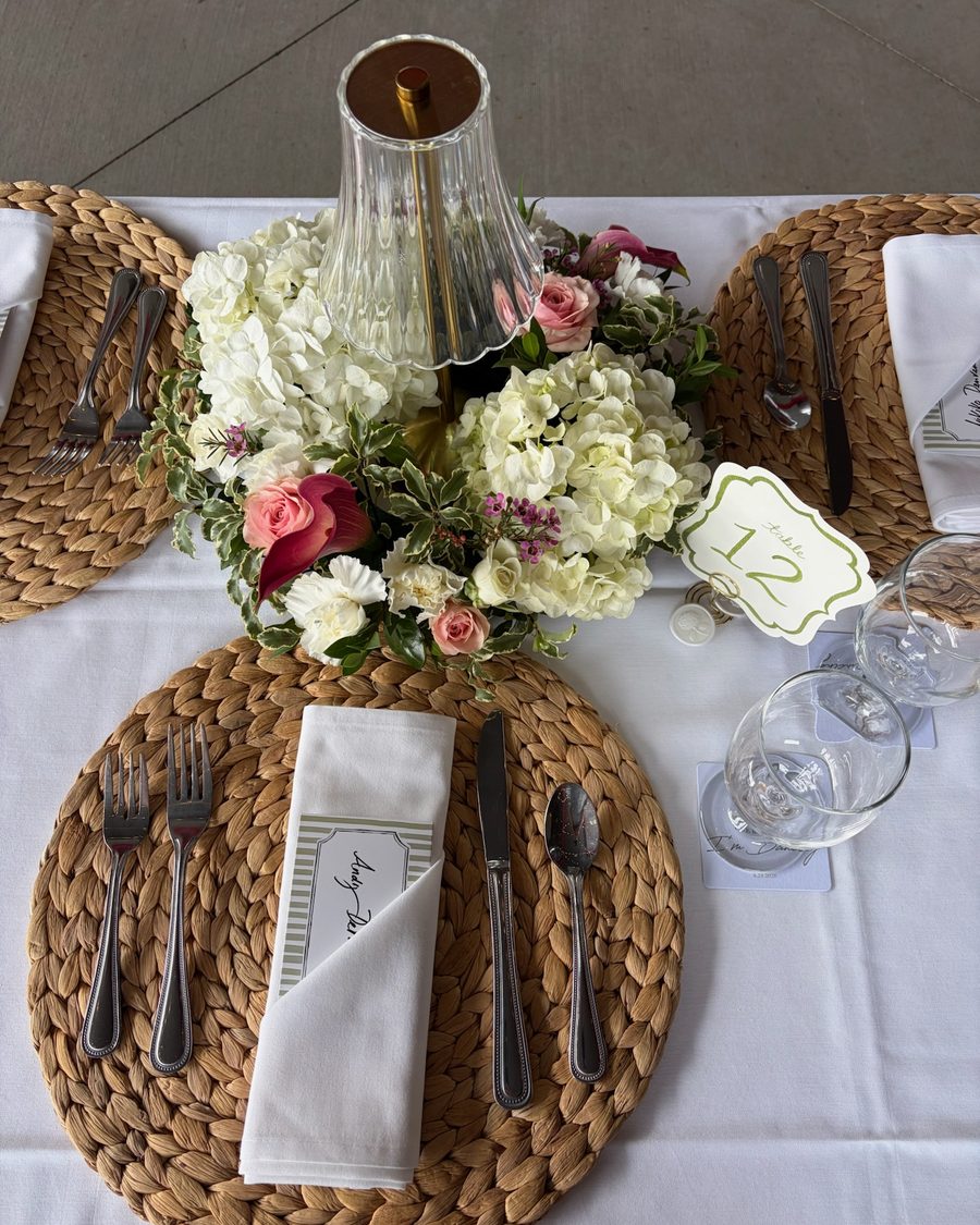 White hydrangea centerpiece with pink roses on a woven charger